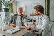 © Miljan Živković - Doctor measuring blood pressure of senior patient in medical clinic