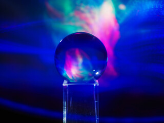 Wall Mural - a clear glass ball is sitting on a pedestal. colorful background. abstract graphic background. light