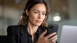 © admin_design - Professional businesswoman in a stylish black suit attentively checks her smartphone for important updates, showcasing modern corporate communication and technology in business setting.
