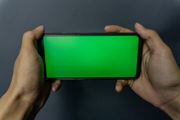 Hands Holding Smartphone with Green Screen