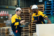 © Ekkasit A Siam - Warehouse male workers cooperating during stock inspection task, one asian adult using laptop while one african adult checking boxes, teamwork concept in industrial logistics space