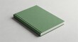 © Alia - Simple blank green hardcover book with textured cover resting on a light background, ideal for mockup and copy space.