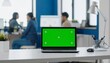 © Peyek - Laptop with Green Screen in Modern Office Setting