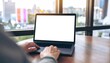 © Peyek - Man using Laptop with Blank White Screen Display for Mockup in Modern Office, Business Technology Concept