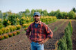 © Drazen - Happy plant nursery owner in field looking at camera.