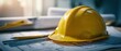 © Studio Nova - The yellow hardhat resting on blueprints in a bright construction workspace.