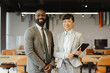© Westend61 - Confident business colleagues smiling in modern office