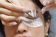 © Jirawatfoto - Calm young southeast asian woman undergoes professional eyelashes extension procedure for natural beauty. female at beauty salon focuses on eyes health and wellness makeup