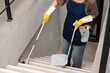 © Natee Meepian - Stair Cleaning. Woman using mop and bucket for thorough home maintenance.