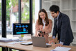 © Wasana - A man and a woman are looking at a laptop and a cell phone