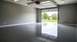 © Valiantsin - Empty garage with epoxy floor and open door revealing yard, reminiscent of unfurnished apartments awaiting personal touch
