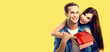 © vgstudio - Holiday sales, price discounts, celebrating ad concept - happy smile cute couple pointing red gift box. Portrait of young man, woman, isolate yellow background. Banner image with free space