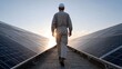 © ittipol - A technician walks between solar panels at sunset, showcasing the future of renewable energy and sustainable technology.