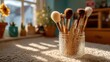 © Roksanara - Makeup brushes in a jar sit bathed in light from window