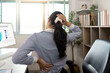 © Natee Meepian - Office Syndrome: Young Woman Stretching Neck and Back at Desk