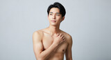 胸に手を当てる上半身裸の若い日本人男性