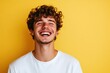 © Ольга Лукьяненко - Young man laughing against vibrant yellow background