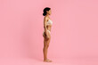 © Anastasiya - Side profile of fit young African American woman in beige underwear on pink background. Healthy curves and natural confidence ideal for wellness, body positivity and fashion themes