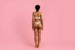 © Anastasiya - Rear view of a young African American woman in beige underwear standing confidently on a pink studio background. Emphasizing tone, strength, and feminine form for wellness content