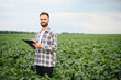 © Serhii - Agronomist taking notes in cultivated soybean field