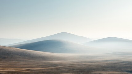 Rolling hills are covered in morning mist and diffused sunlight