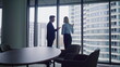 © stockbusters - Businesswoman businessman discussing project looking city in panoramic window