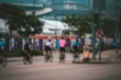 © joeycheung - Blurred background of a busy street in Hong Kong with people riding bicycles.