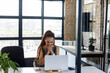 © Wavebreak Media - African American mid adult woman sitting at modern workspace desk using laptop and smartphone