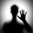 © freelanceartist - black and white photograph shows of a blurred silhouette of a man behind a matte or translucent surface. The hand is clearly pressed against the surface. eerie image, emotional expression, conceptual