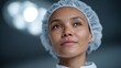 © BOJOShop - Close up portrait of a woman in a hair net looking up thoughtfully illuminated by bright lights