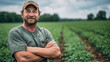 © Jhati - A farmer standing with crossed arms in front of a field of crops