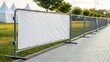 © RmGraphix - Outdoor metal crowd control barrier with a blank white banner for advertising or information