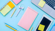 © RB 4k Photo  - Flat lay of a laptop tablet notebooks pencils and earphones on a light blue colored background