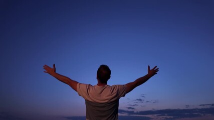Wall Mural - man with arms wide open enjoying outdoors during blue hour time in nature.