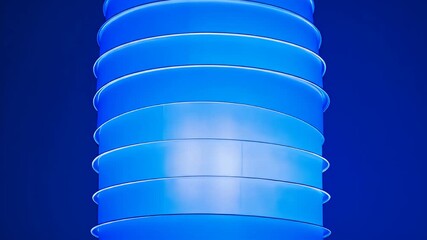 Wall Mural - stacked blue cylindrical shapes glow with light against a matching blue background