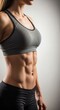© IbragimovN - Fit woman demonstrating defined abs in athletic wear on neutral background