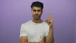 © Krakenimages.com - Man in white t-shirt pointing index finger upward in studio with serious gaze and focused posture; confidence.