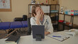 © Krakenimages.com - Woman doctor wearing stethoscope adjusts glasses at a white desk in clinic while reviewing patient chart; fatigue.