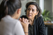 © AI_images - Mature Hispanic woman coaching a junior colleague on conflict resolution, demonstrating empathy and clear communication