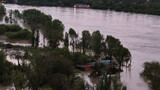 Aerial view of severe river flooding inundating agricultural land and trees with houses partially submerged in water during the early evening twilight hours in Castelvetro Piacentino Italy