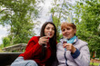 © Nataliya - Cheerful granddaughter and grandmother celebrate birthday on a boat with a drink.
