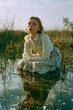 © Erik González - A woman is sitting in a pond wearing a white dress
