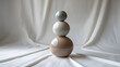 © Salman - Artistic portrait photography of three ceramic spheres in tiny, small, and medium sizes stacked off-center on a crisp paper-white backdrop, with a shallow depth of field, soft natural lighting