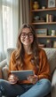© natakot - Cheerful woman with glasses holding a tablet