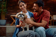 © Drazen - Happy pet owners with dog enjoying on their porch.