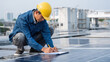 © valeo5 - Worker in hard hat inspects solar panels on roof, taking notes on clipboard. Image represents growing renewable energy sector, technical jobs, installation and maintenance of green technology