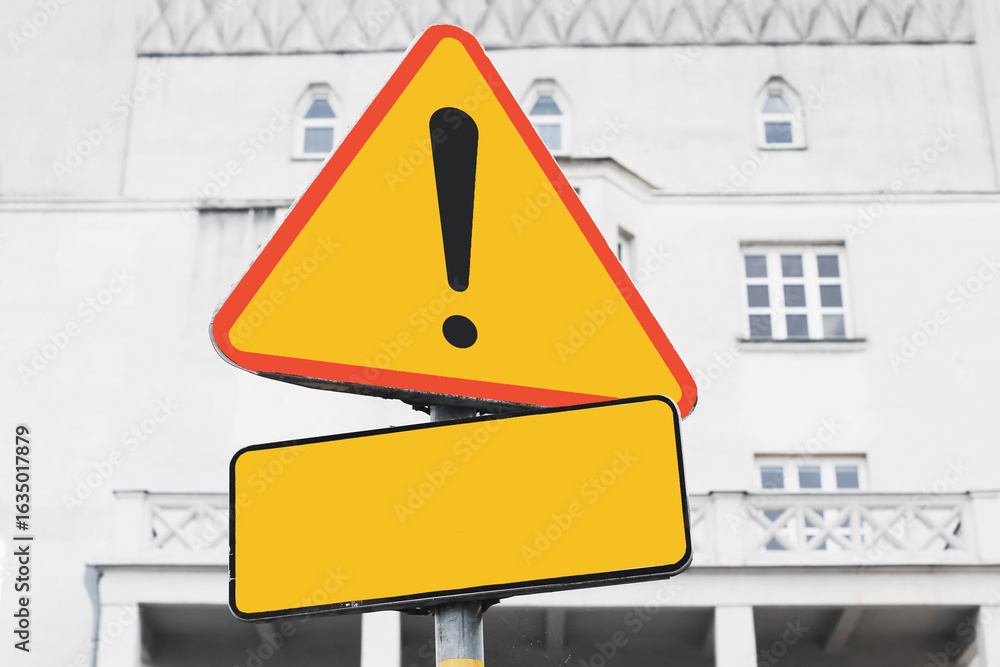 Warning sign with exclamation mark. Bright yellow triangle on urban ...