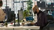 © DC Studio - Arab office clerk working to hit key performance targets for revenue, profitability and operational efficiency. Middle Eastern employee at PC desk doing research analysis, camera A