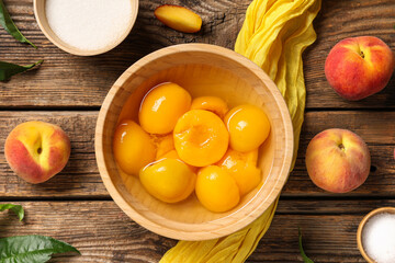 Wall Mural - Composition with bowl of canned peaches, fresh fruits and sugar on wooden background
