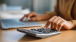 © suldev - Close up, business woman working at office, using calculator to calculate company finance, accounting with laptop computer on table, budget management. Doing finance, budgeting and tax calculation